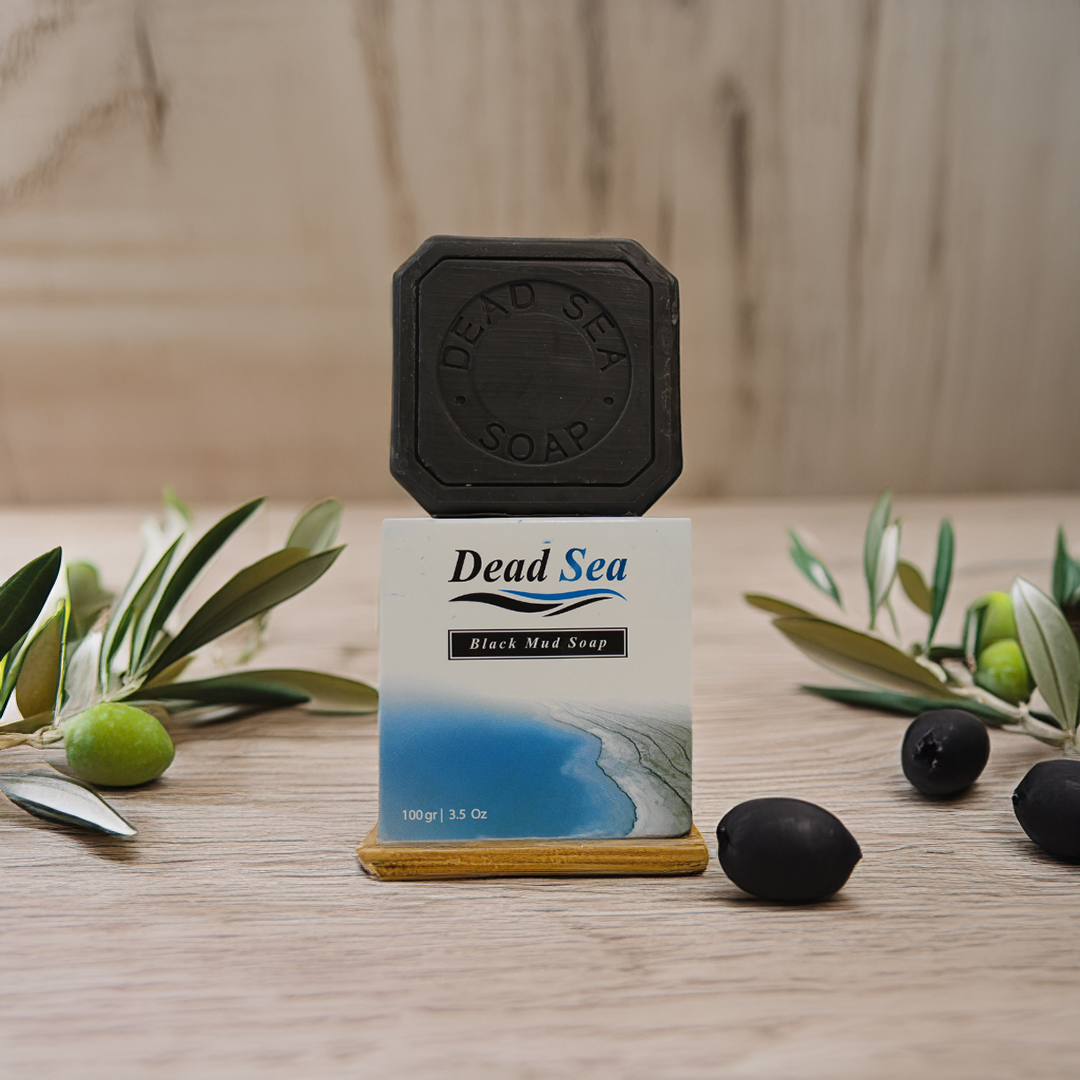 A bar of black mud soap with olive oil made by nablus soap with olives and olive branches around it